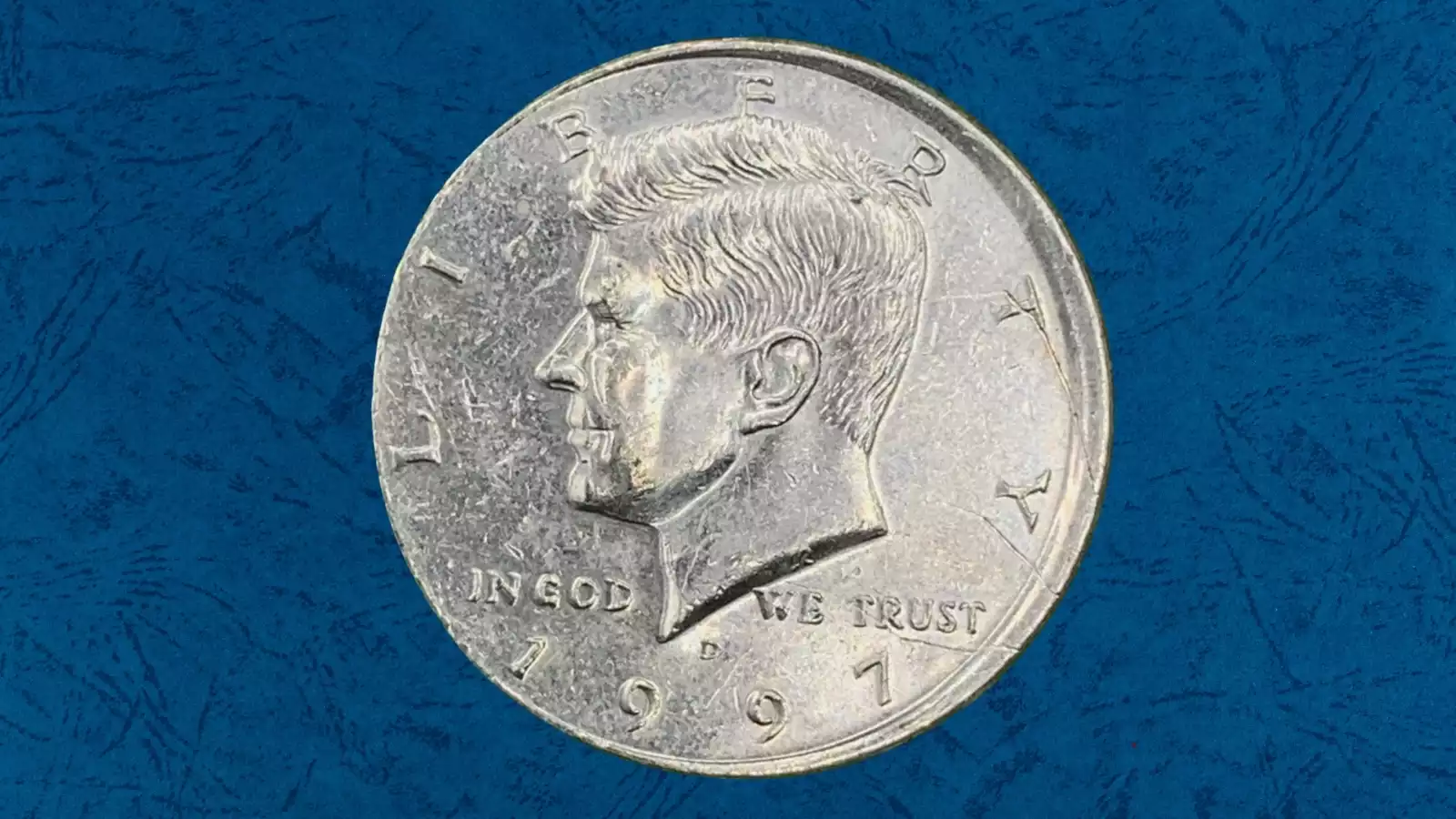 1997 Kennedy Half Dollar off-center strike error showing blank crescent area and shifted JFK portrait design
