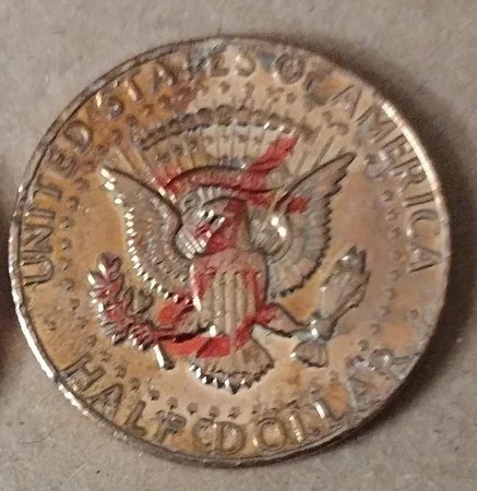 1997 Kennedy Half Dollar missing clad layer error showing reddish-copper exposed face on one side