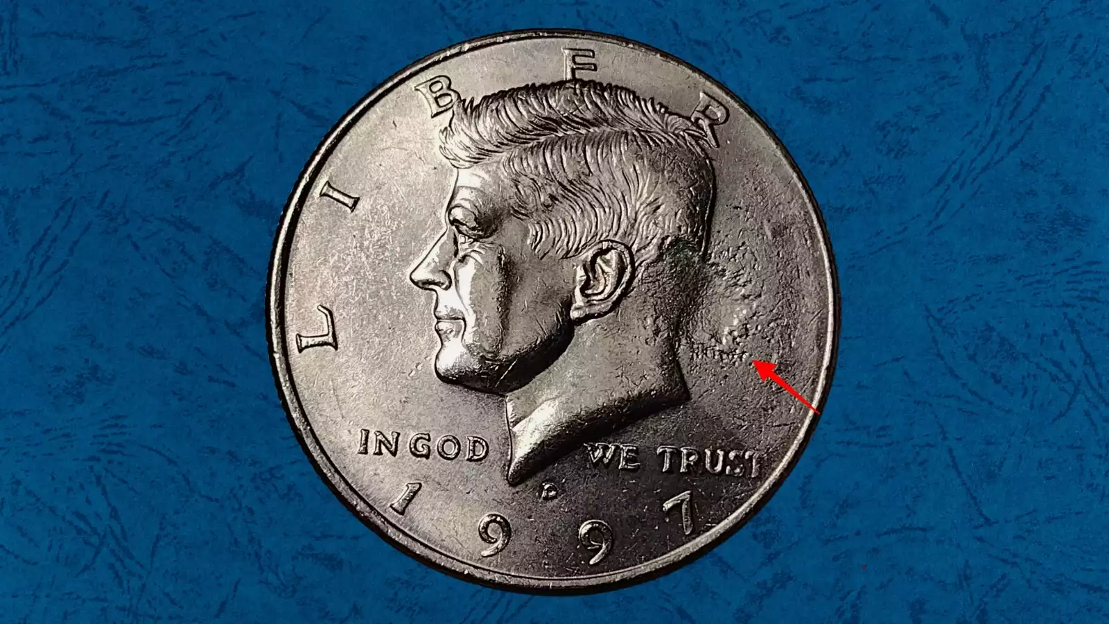 1997 Kennedy Half Dollar strike-through error showing blurred and missing design detail from debris caught between die and planchet